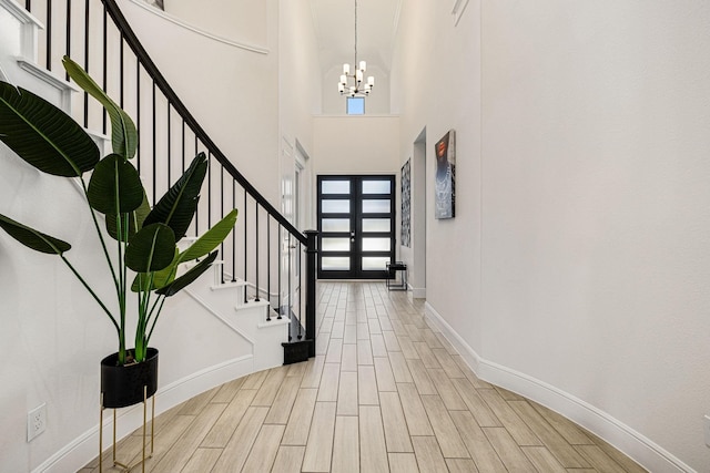 foyer with french doors, an inviting chandelier, and a high ceiling