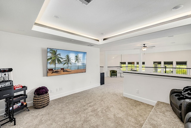 carpeted home theater with a tray ceiling