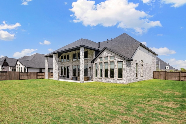 rear view of house featuring a lawn and a patio