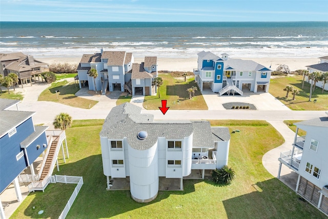 drone / aerial view with a water view, a residential view, and a view of the beach