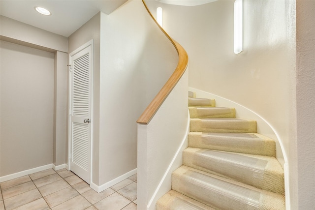 stairway featuring tile patterned flooring and baseboards