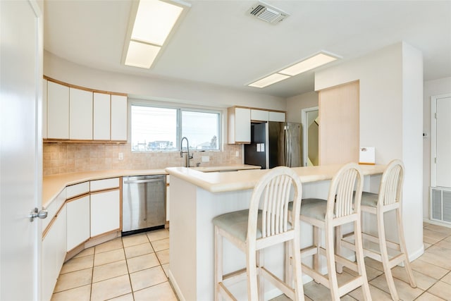 kitchen featuring white cabinetry, appliances with stainless steel finishes, and decorative backsplash