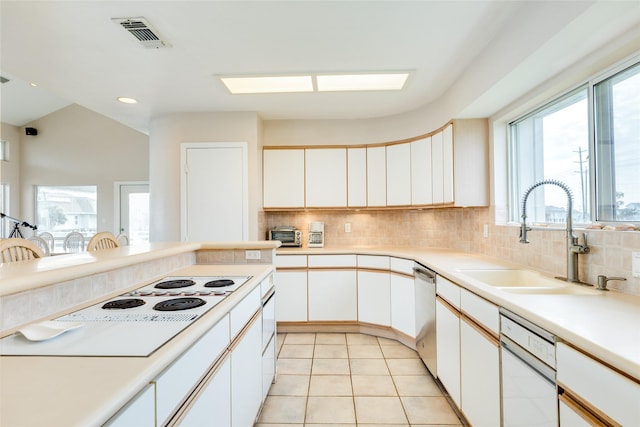 kitchen featuring tasteful backsplash, white cabinetry, sink, and white appliances