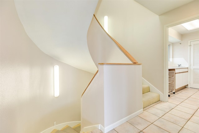 stairway with tile patterned flooring and sink