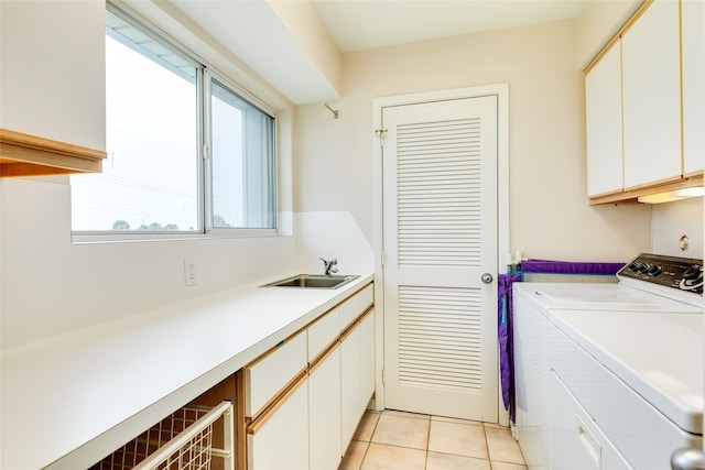 laundry room featuring cabinets, washing machine and dryer, sink, and light tile patterned floors