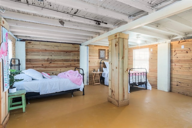 bedroom featuring finished concrete flooring and wood walls