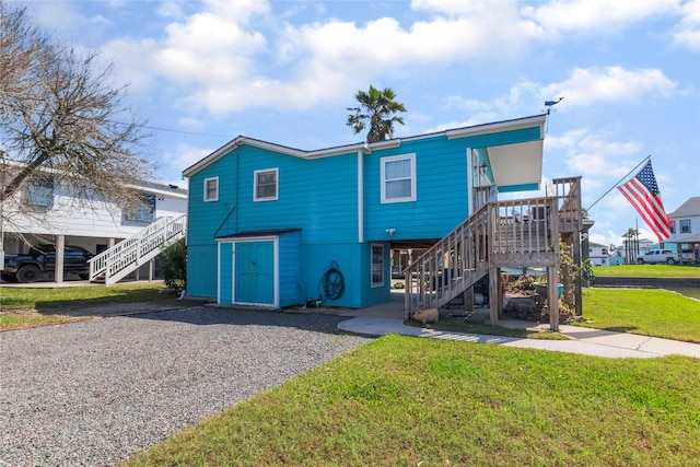 beach home with a front yard and stairs