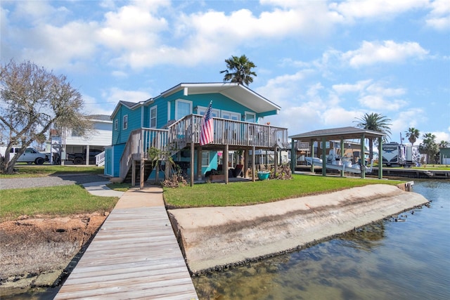 rear view of property with a water view and a yard