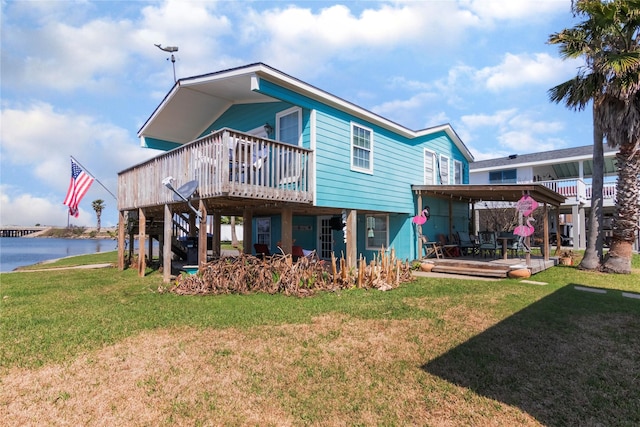 rear view of house with a deck with water view, a yard, and stairway