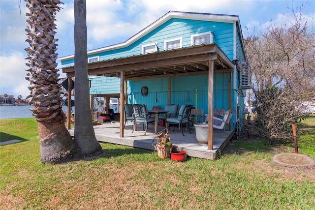 back of property featuring a deck with water view and a yard