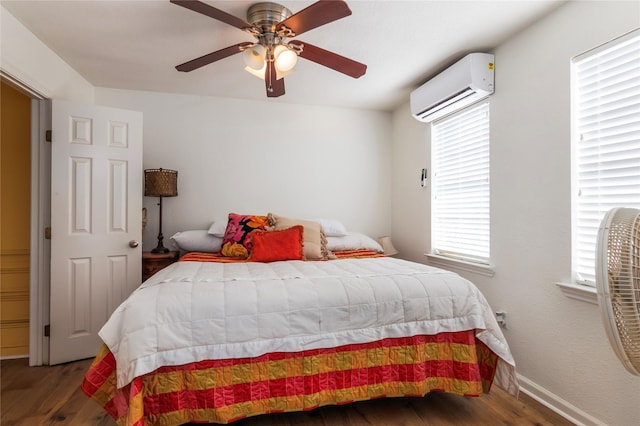 bedroom featuring an AC wall unit, wood finished floors, a ceiling fan, and baseboards