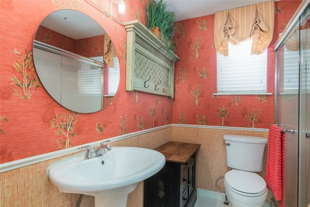 full bath featuring a wainscoted wall, a sink, and wallpapered walls