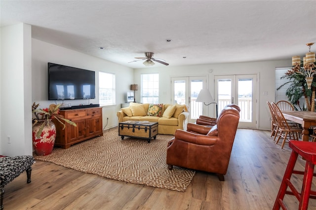 living area with french doors, a healthy amount of sunlight, and wood finished floors