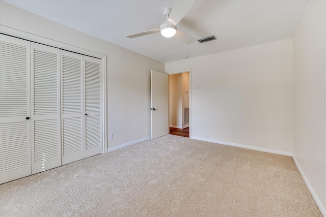 unfurnished bedroom with light carpet, a closet, and ceiling fan