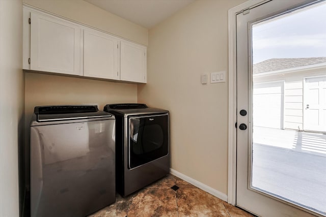 washroom with cabinets, washing machine and dryer, and a wealth of natural light