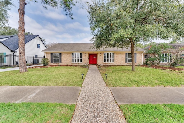 single story home featuring brick siding, cooling unit, a front lawn, and fence