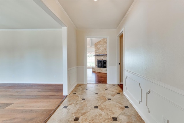 corridor with ornamental molding and light hardwood / wood-style floors