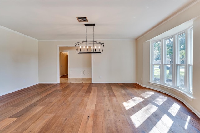 unfurnished dining area featuring a notable chandelier, crown molding, and light hardwood / wood-style floors