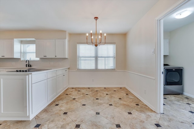 kitchen featuring sink, decorative light fixtures, a notable chandelier, washer / clothes dryer, and white cabinets