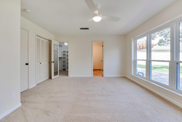 unfurnished bedroom with ceiling fan and light carpet