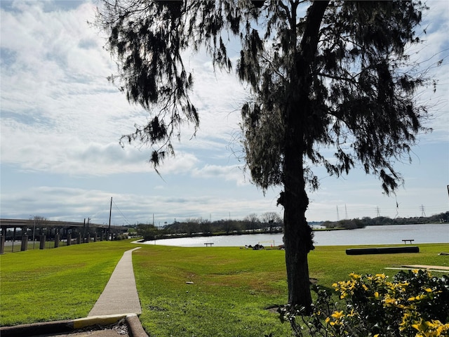 view of home's community with a water view and a yard