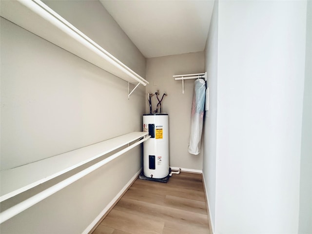 spacious closet with light wood-style floors and electric water heater