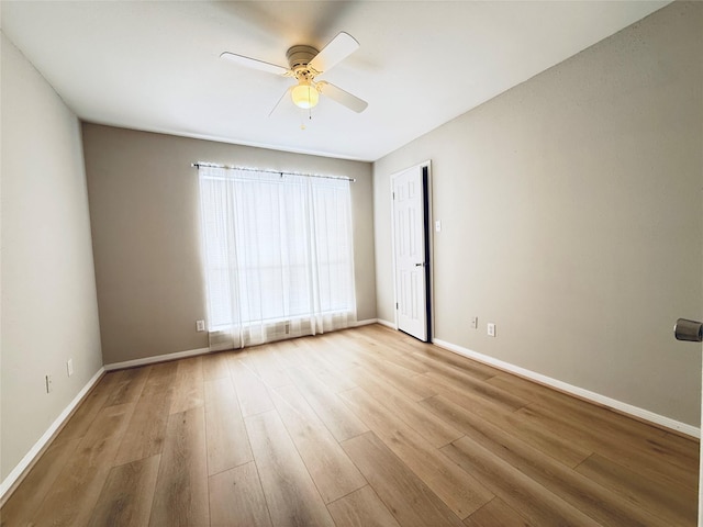 unfurnished room with a ceiling fan, baseboards, and wood finished floors