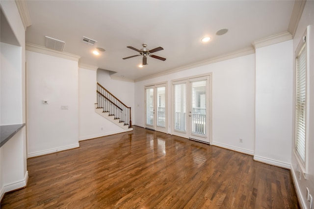 spare room featuring crown molding, dark wood finished floors, visible vents, baseboards, and stairs