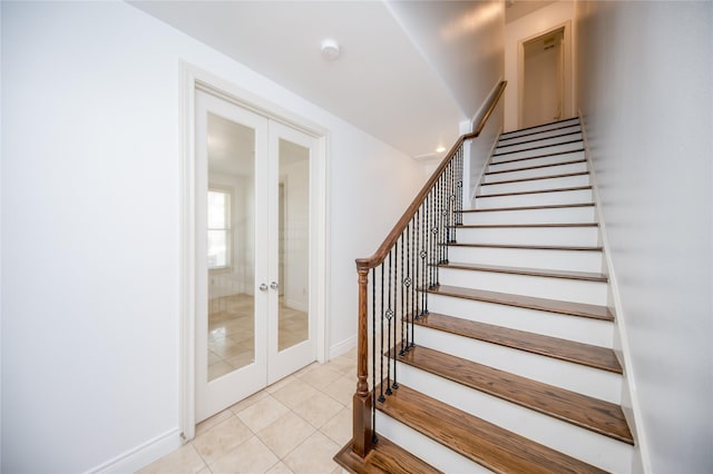 stairs featuring baseboards, french doors, and tile patterned floors