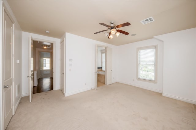 unfurnished bedroom featuring baseboards, visible vents, a ceiling fan, and light colored carpet