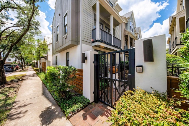 view of property exterior featuring fence, a gate, and stucco siding