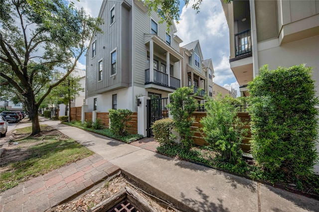 view of home's exterior with brick siding, fence, a residential view, and stucco siding