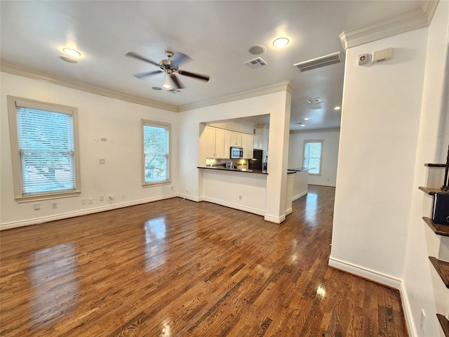 unfurnished living room featuring ceiling fan, ornamental molding, dark wood-style flooring, and visible vents