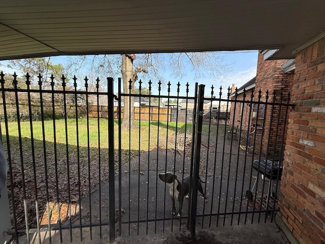 view of gate with a lawn