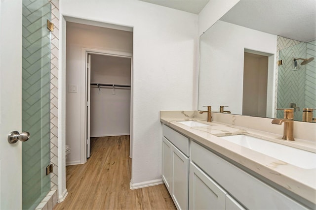 bathroom featuring vanity, wood-type flooring, and a shower with shower door