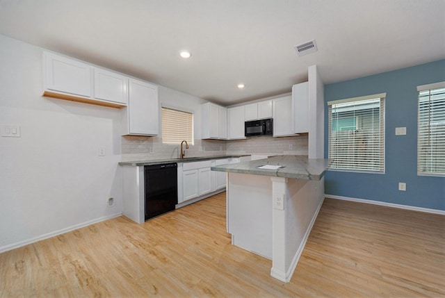 kitchen with light hardwood / wood-style flooring, backsplash, black appliances, white cabinets, and kitchen peninsula