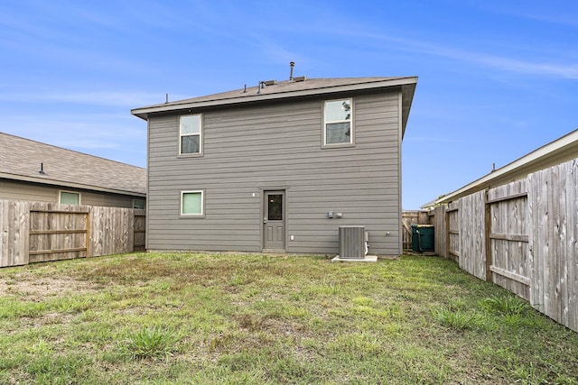 back of house with a yard and central air condition unit