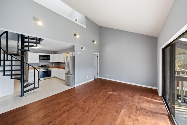 unfurnished living room with light hardwood / wood-style flooring and high vaulted ceiling