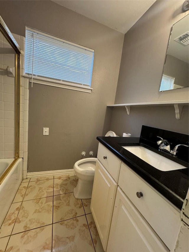 full bathroom with vanity, bath / shower combo with glass door, and toilet