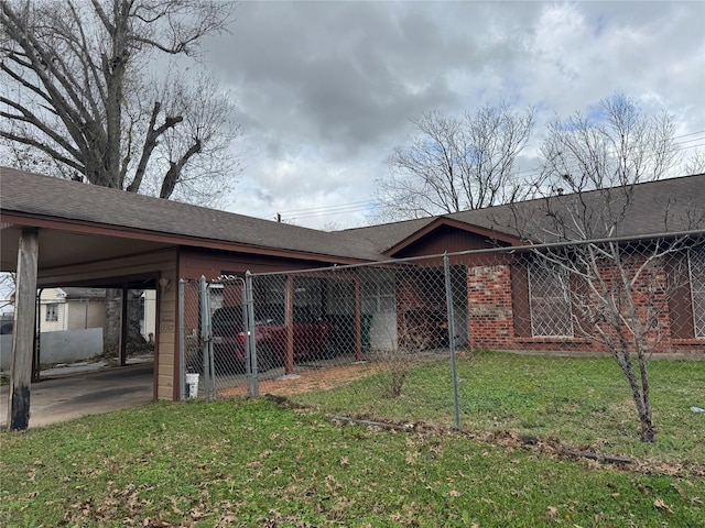 back of house with a lawn and a carport