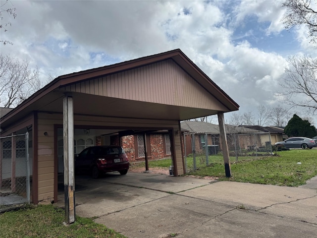 view of parking / parking lot with a carport and a yard