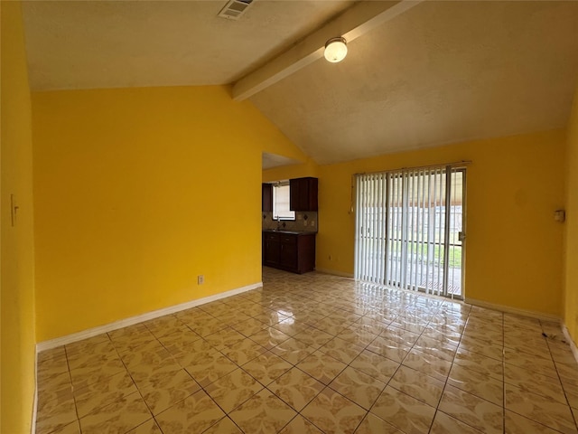 empty room with sink and vaulted ceiling with beams