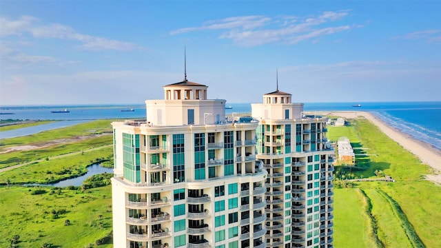 view of building exterior with a beach view and a water view