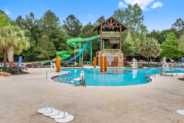 community pool featuring playground community, a water slide, and a water play area