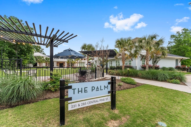 community sign with fence and a lawn