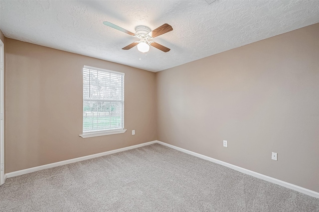 carpeted spare room featuring a textured ceiling, baseboards, and ceiling fan