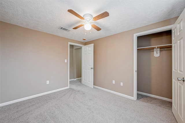 unfurnished bedroom with carpet, visible vents, baseboards, a closet, and a textured ceiling