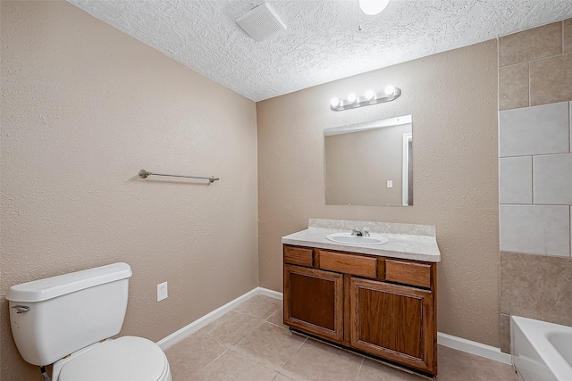 bathroom featuring tile patterned flooring, toilet, vanity, a bath, and a textured ceiling