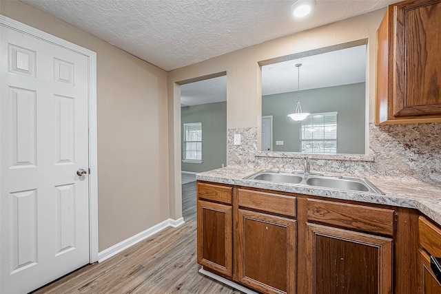 kitchen featuring light countertops, tasteful backsplash, a wealth of natural light, and a sink