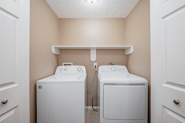 clothes washing area featuring washer and clothes dryer, laundry area, and a textured ceiling